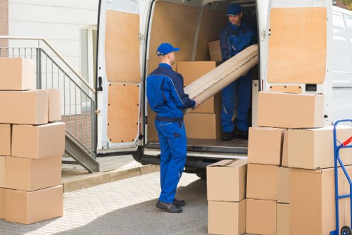 Removal team handling flat moving equipment in Colliers Wood